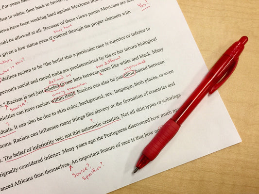 Red pen editing a page of text for book lovers