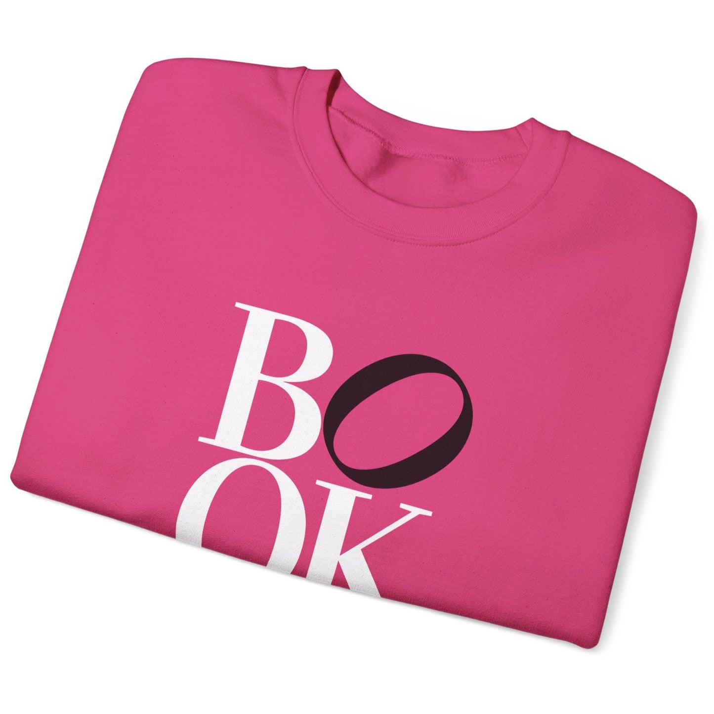 Folded pink sweatshirt with 'BOOK' printed on it against a white background