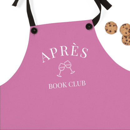 Pink apron with 'APRÈS BOOK CLUB' text and wine glass graphics on a white background.