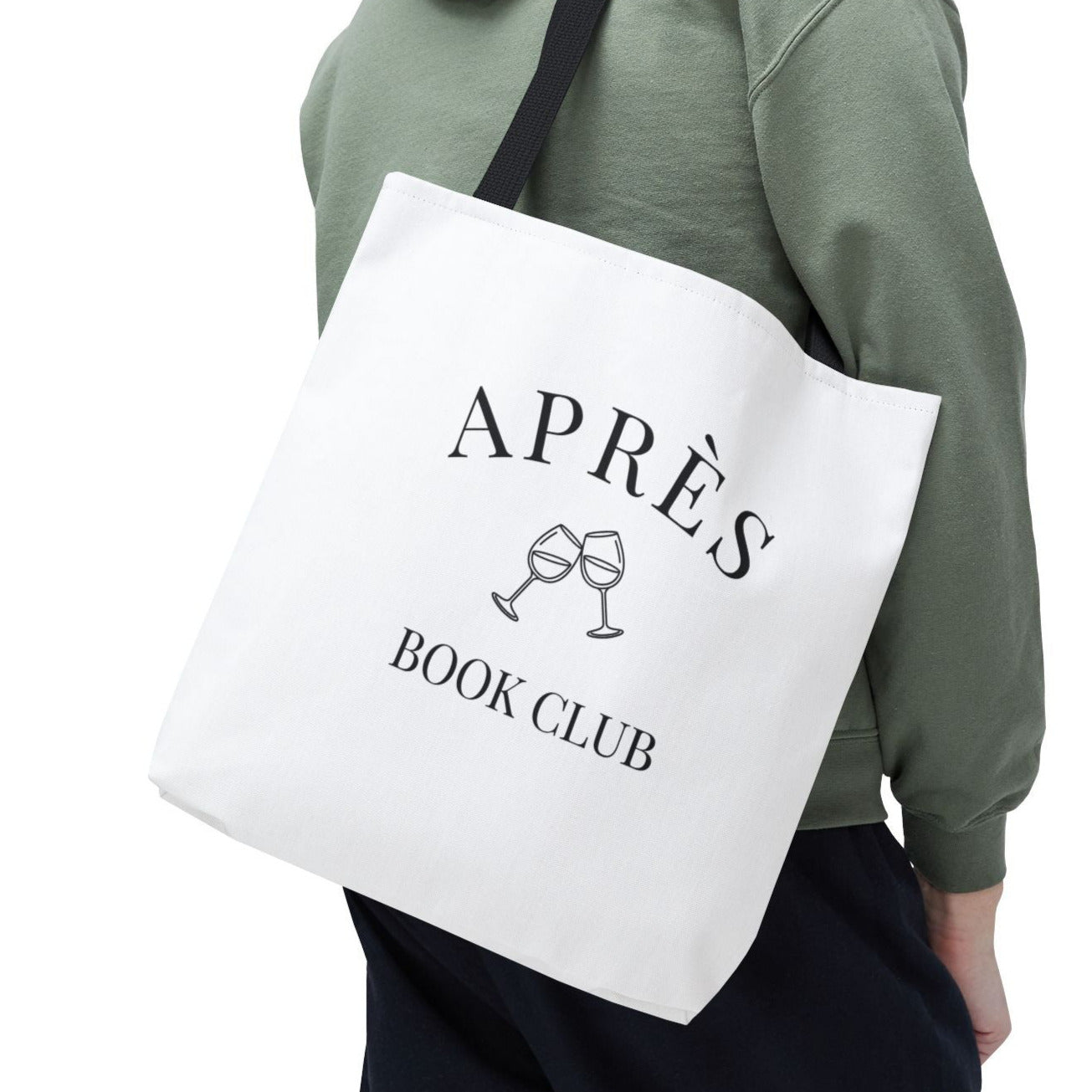 Person wearing a green hoodie holding a white tote bag with 'APRèS BOOK CLUB' text.