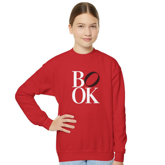 Person wearing a red sweatshirt with 'BOOK' printed on it against a white background